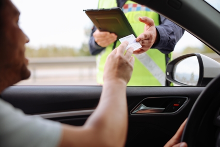 Policeman in uniform traffic control to male driver