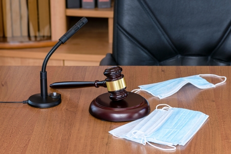 PPE mask and gavel resting on Judge's bench
